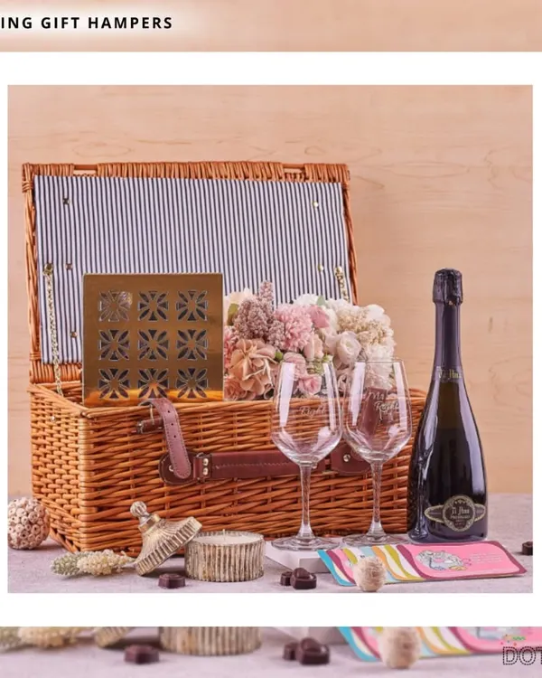 I designed this elegant wedding hamper as the perfect romantic gesture for newlyweds. It includes a classic wicker picnic basket, sparkling wine, engraved glasses, and a selection of fine chocolates and flowers, setting the scene for a memorable celebration.