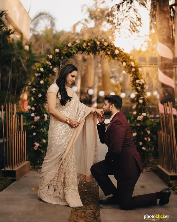 The classic proposal pose during an engagement ceremony, set against a beautiful floral arch. We capture these iconic moments with a soft, romantic feel.