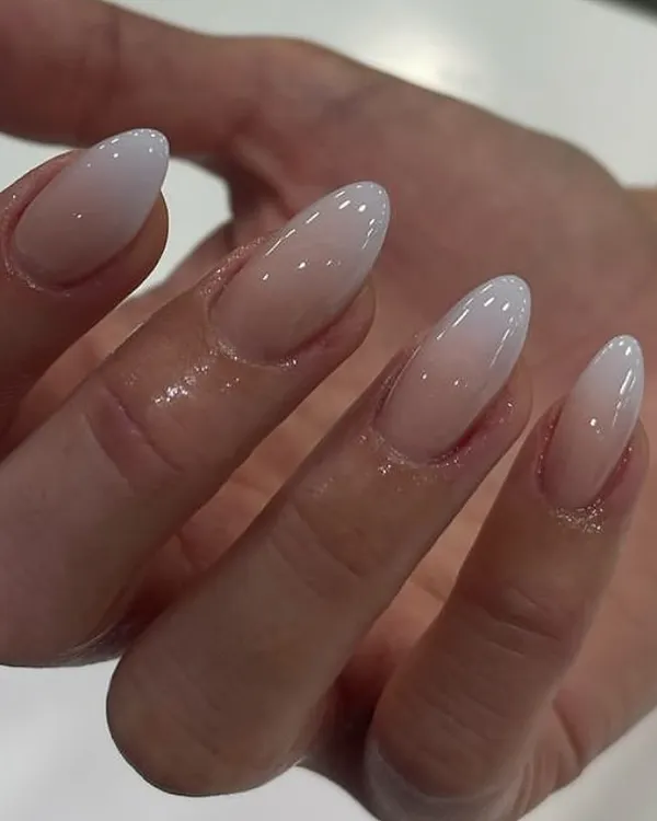 A perfect example of a classic 'baby boomer' ombré, with a seamless blend from a soft nude base to a milky white tip on almond-shaped nails.