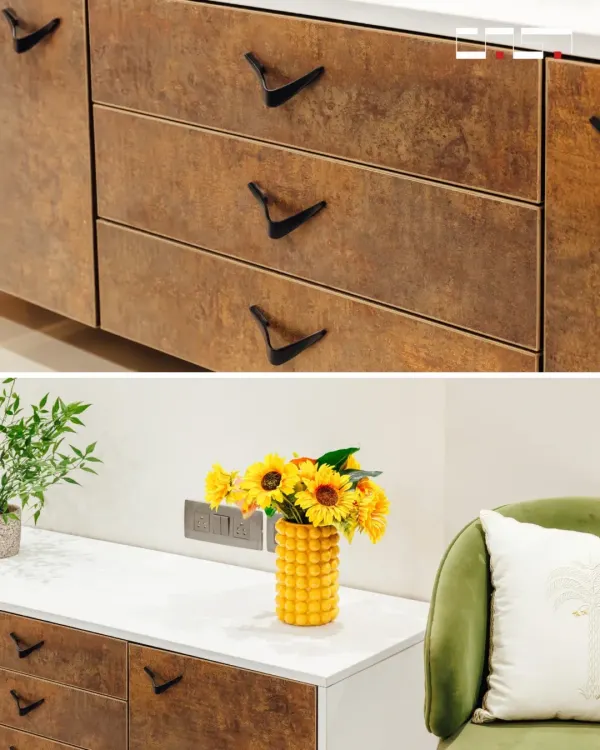 Details matter. This image shows the unique, wing-like black handles on rustic-finish drawers, contrasted with a bright yellow vase on a clean white countertop.