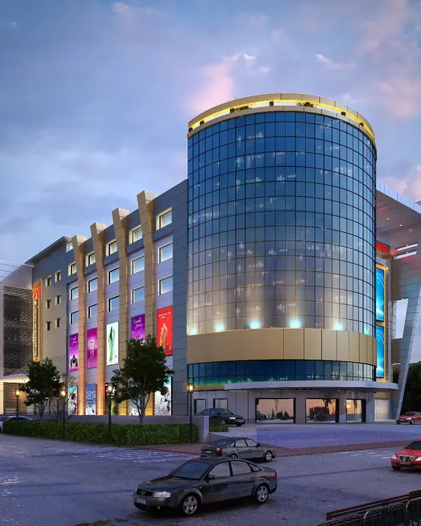 A design proposal for a large-scale shopping complex. The building's centerpiece is a cylindrical glass tower that serves as a visual anchor, designed to house flagship stores and create a modern, inviting hub for retail and social activity.