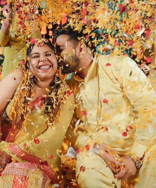 An explosion of flower petals and happiness during a 'phoolon ki haldi'. This shot perfectly captures the energy and vibrancy of the event.