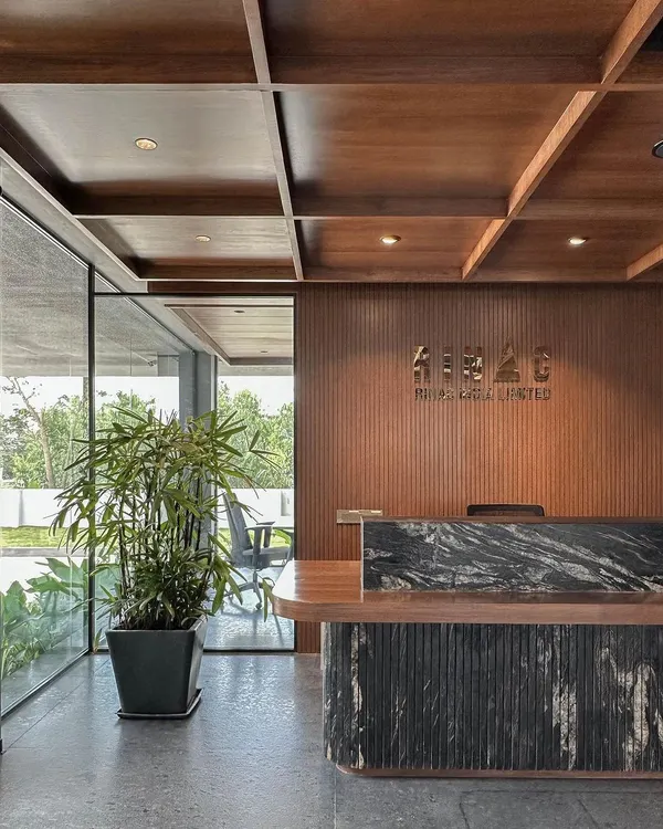 The main reception desk at RINAC HQ, featuring a custom black granite top and a coffered wood ceiling. This space immediately communicates a sense of quality and established professionalism.