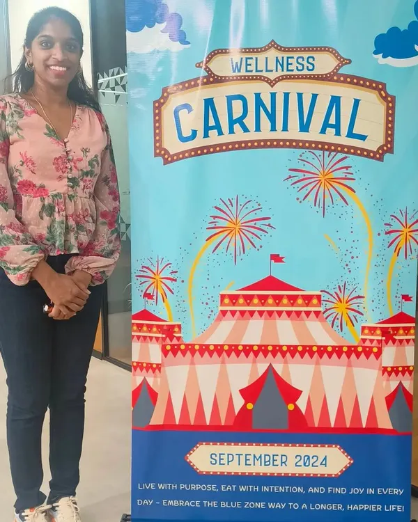 Proudly standing by our 'Wellness Carnival' banner. These events are designed to be vibrant, engaging, and packed with activities that make health feel like a celebration, not a chore. It's all about creating a positive and energetic atmosphere for employees.