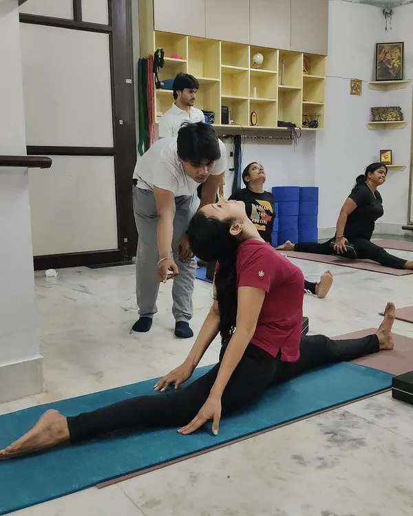 Personal attention is key to progress. Here, I am assisting a student to safely deepen her split, ensuring correct alignment to prevent injury and improve flexibility.