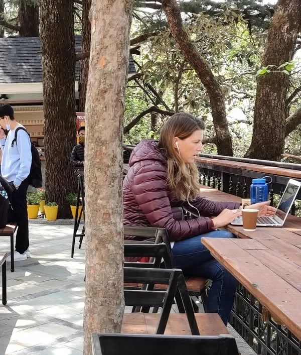 A student finds a quiet spot to work at the community hub we designed for Woodstock School. The flexible urban furniture, made from upcycled wooden decks, allows for various uses, from solo study to group gatherings.