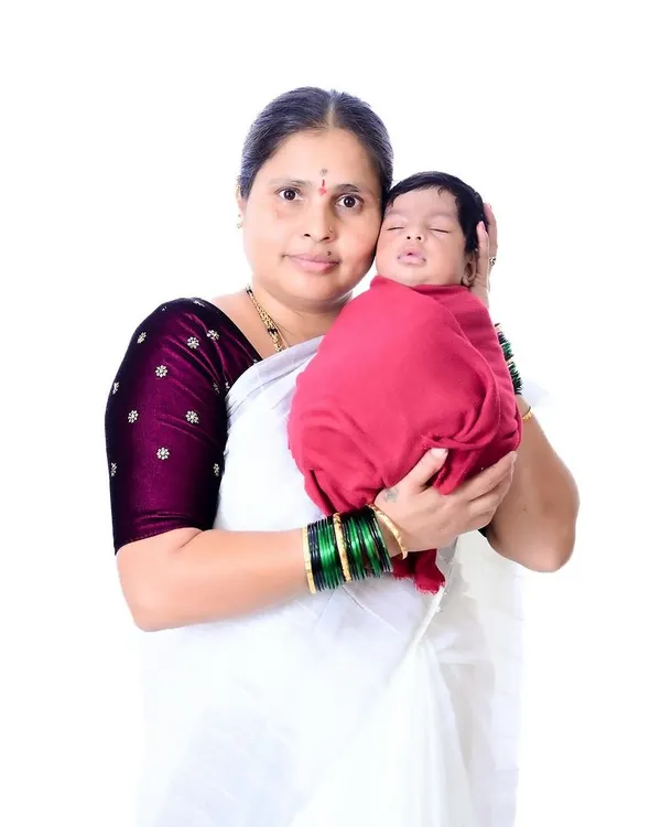 A grandmother's gentle embrace. This portrait captures the pride and unconditional love in her expression as she holds her newborn grandchild, a beautiful moment of connection.
