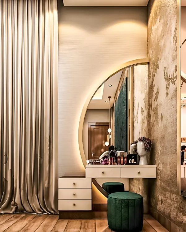 An elegant dressing table with a large, backlit semi-circular mirror. The design includes drawers for storage and is paired with plush green stools, creating a glamorous and functional vanity corner.