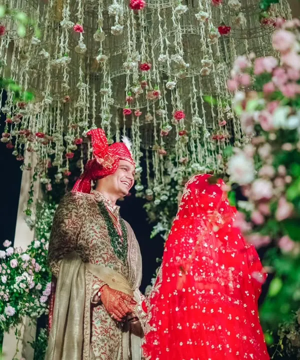 A romantic portrait of the couple under a canopy of cascading jasmine and rose buds. This intricate floral work inside the mandap created a dreamy and fragrant setting for their vows.