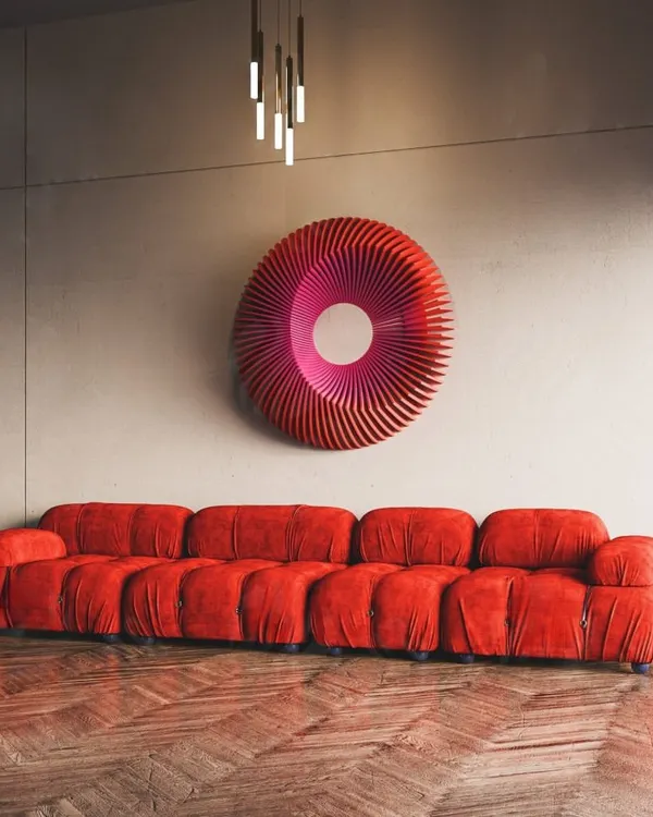 Our 'Art No.11' Radiant Circles sculpture in a dramatic red, paired with a matching sofa. The piece's wavy, circular form creates a stunning optical effect.