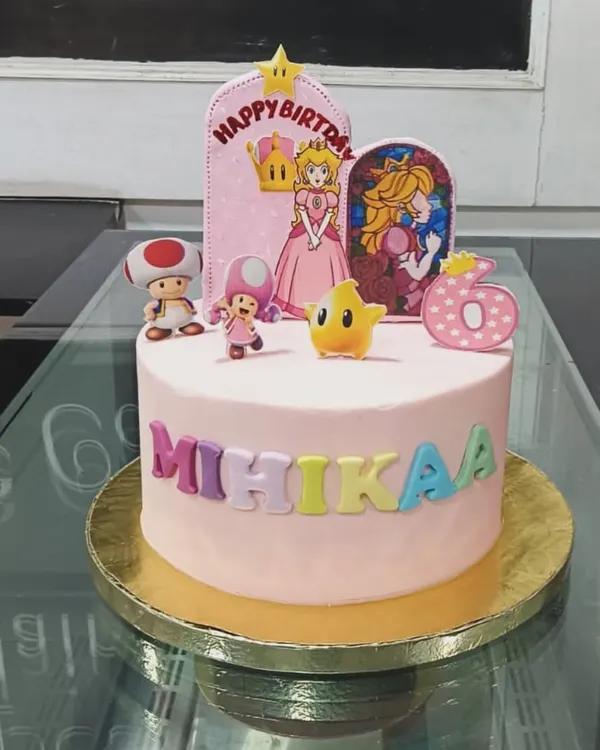 A delightful Princess Peach and Super Mario themed cake for a 6th birthday. This pink cake features fondant characters and colorful lettering to celebrate a special day.