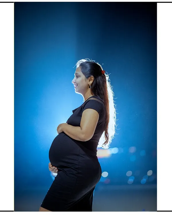 A dramatic night portrait using a single light source to create a stunning silhouette of the mom-to-be. This artistic style is perfect for a unique and memorable photo.