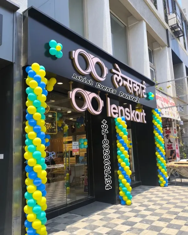 A grand opening decoration for a Lenskart store in Panvel. The blue, yellow, and green spiral balloon pillars are designed to be vibrant and welcoming to new customers.