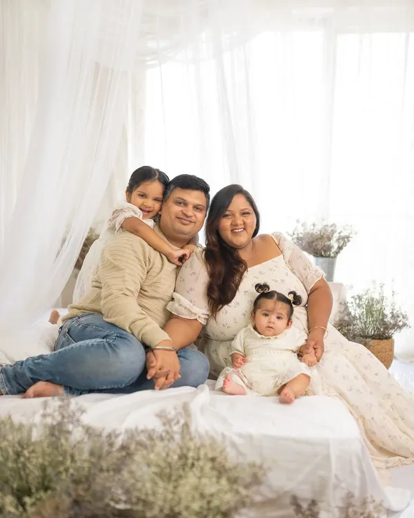A full family portrait in my bright and airy studio. This setup features a comfortable bed, soft white fabrics, and delicate dried flowers for a warm, lifestyle feel.