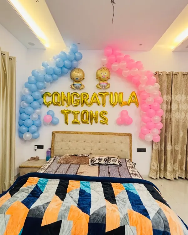 A sweet 'Congratulations' setup for welcoming twins. I used pink and blue balloon arches over the bed with baby-themed foil balloons.