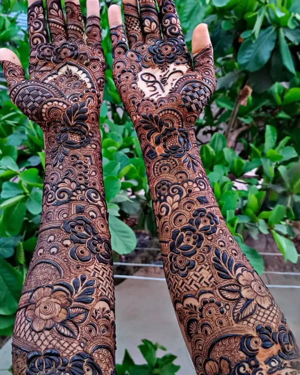 A full bridal design with beautiful, bold floral work and a heart holding the couple's initials. I love how the dark and light shades create so much depth in this intricate henna pattern.
