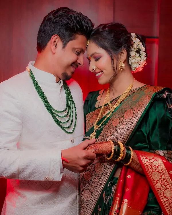 An intimate engagement portrait. The couple holds hands, their foreheads touching, in a moment of quiet connection. The warm, dramatic lighting adds to the romantic feel of the photograph.