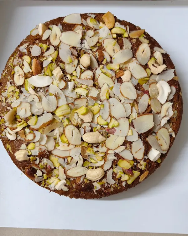 My Whole Wheat Jaggery Cake is a bestseller for a reason. It's a dense, moist cake made with atta and gud, and absolutely covered in a mix of healthy nuts and dry fruits.