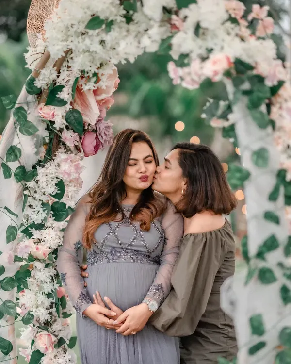 The joy of celebrating with loved ones. Here, the mom-to-be shares a sweet moment with a friend under a beautiful floral arch we created for her outdoor baby shower.