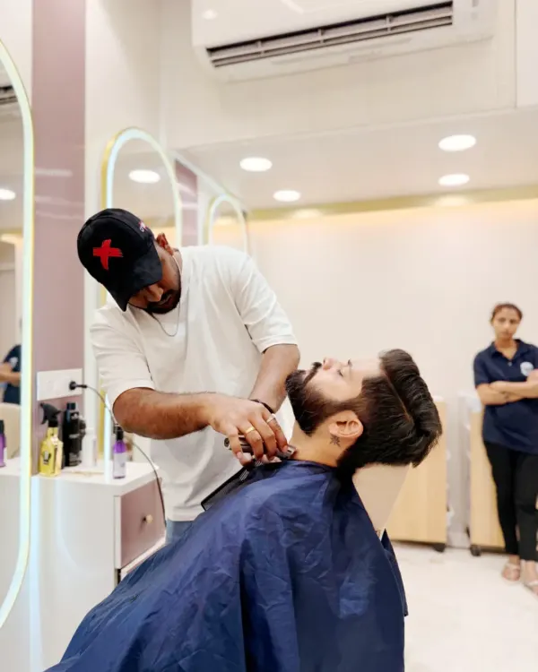 A client relaxes while our expert stylist provides a detailed beard trim. We create a comfortable and professional environment for all our men's grooming services.