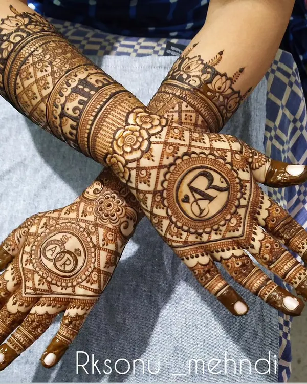 A lovely design for a ring ceremony, featuring the couple's initials inside a decorative mandala. The pattern is intricate but focused on the center of the palm, leaving space for a light and elegant feel.