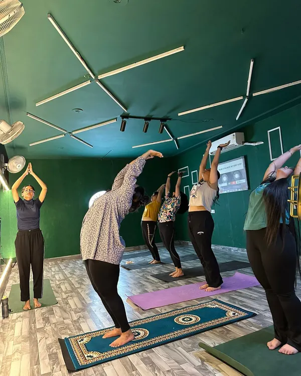 Finding balance and strength in our group yoga class. Here, our members are practicing a standing backbend, or Anuvittasana, to improve posture and flexibility. Our certified instructor ensures everyone maintains proper form for a safe and effective stretch.