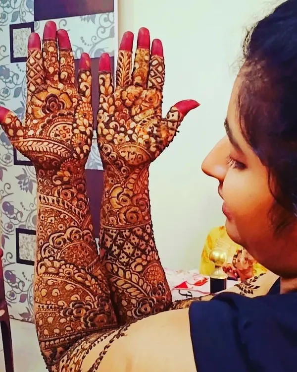 A bride admiring her full-arm mehndi. I love this moment, when the intricate patterns come together to create something truly special for her big day.