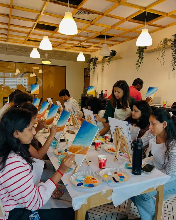 A corporate team fully engaged in a canvas painting workshop. Art is a fantastic way to encourage collaboration and creative thinking outside the office.