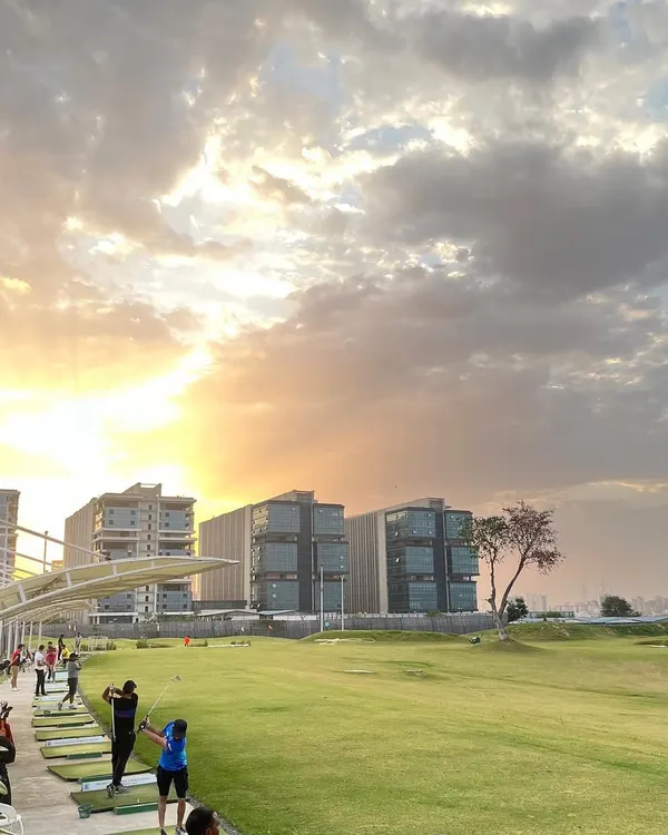 This is the view I want you to experience. Our driving range is a perfect escape from the city's hustle, where you can practice your swing against a stunning sunset and the Gurgaon skyline.