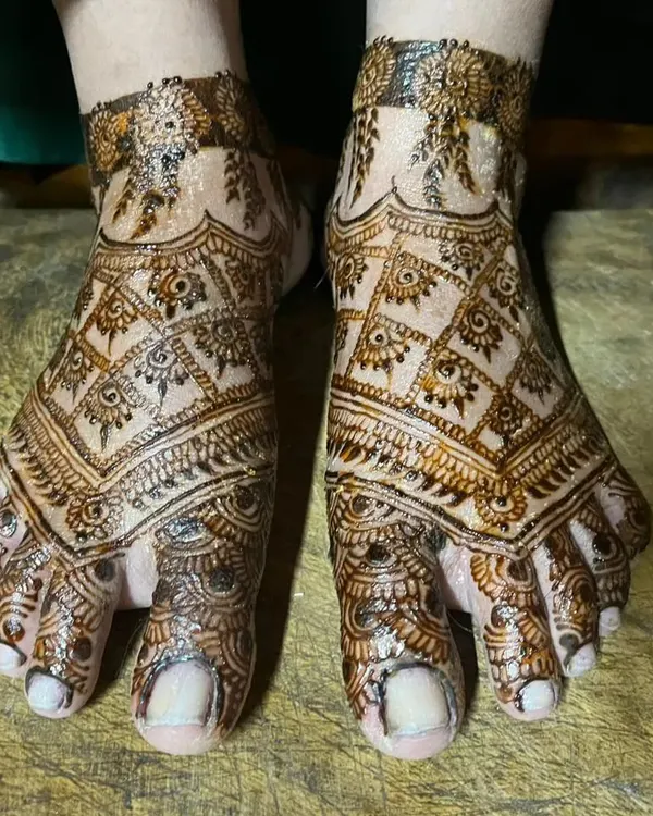 A full-coverage bridal-style mehendi design for the feet. The intricate checkerboard pattern and detailed toe work create a stunning and complete look.