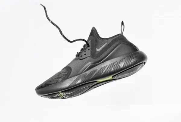 A sleek, all-black sneaker captured mid-air with its lace flying, creating a sense of motion and energy. This dynamic shot is perfect for performance footwear.