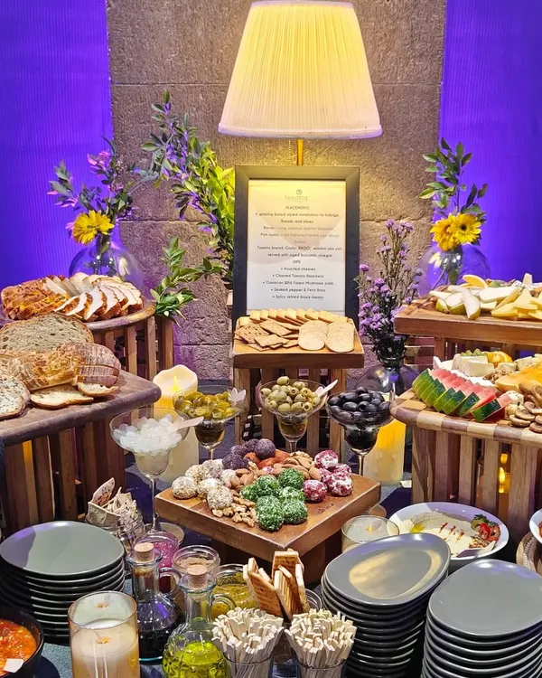 A lavish tapas grazing experience curated for a sophisticated Mercedes tequila soiree. This spread features an extensive selection of artisanal breads, imported cheeses, marinated olives, and handcrafted cheese balls, all designed to complement an evening of high spirits and luxury.