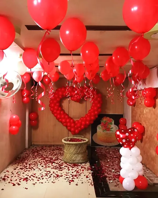 Hero Item. I can transform an entire room into a romantic escape for your anniversary or a special surprise. This setup features hundreds of red balloons on the ceiling, a large balloon heart centerpiece, and rose petals covering the floor for a truly immersive experience.