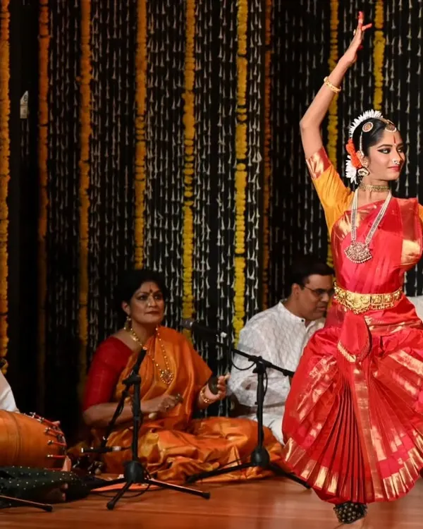 A student's arangetram is a culmination of years of dedication. Here, my shishya Anvita Jain performs on stage, supported by the live orchestra and my guidance from the wings. This moment captures the essence of our shared journey in dance.