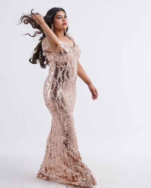 Feel the glamour in this stunning rose gold sequin gown. The way it catches the light is perfect for a fashion shoot, and the movement in the hair adds a dynamic touch.