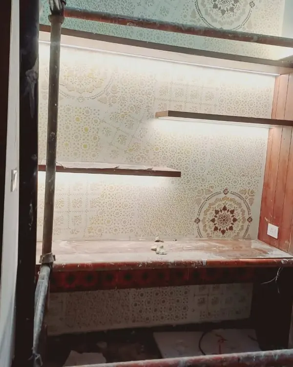 This custom-stenciled study nook features a complex geometric and mandala pattern. The design is integrated with built-in shelving and accent lighting, demonstrating how our work can be tailored to fit specific architectural features.