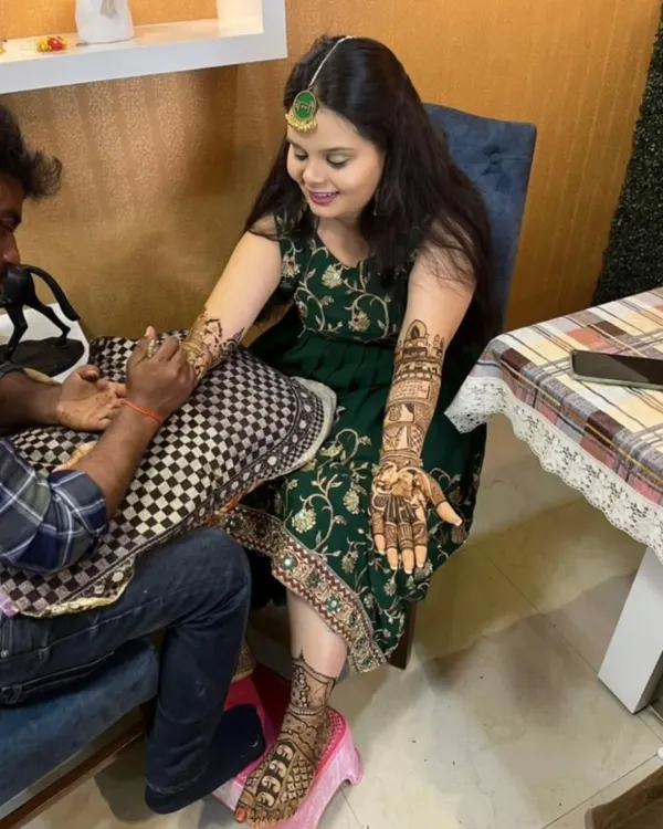 Here I am applying bridal mehandi for a client at her home. You can see her showing off the finished design on one hand while I work on the other.