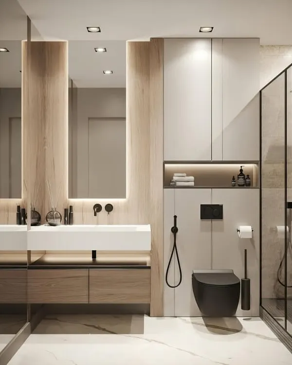 A sleek, modern bathroom with a floating wooden vanity, a minimalist white sink, and built-in storage. The combination of light wood, white surfaces, and black fixtures creates a clean and contemporary look.
