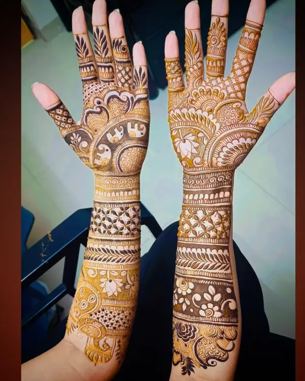 A complete view of a traditional bridal mehandi design. The pattern includes elephant figures, lotus flowers, and intricate check patterns, providing full coverage up to the forearms.