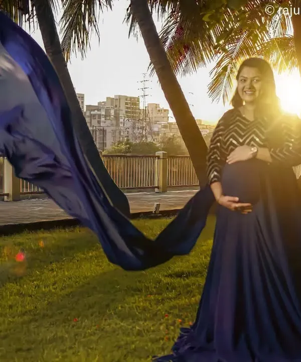 I love creating these cinematic moments for expecting mothers. We caught the perfect sunset light in a Mumbai park for this shot, using a long, flowing blue gown to add a touch of drama and elegance. It’s all about capturing that beautiful pregnancy glow.