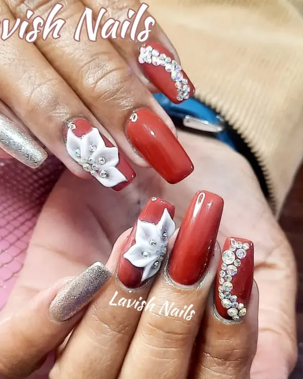 A luxurious set of red and silver nails, featuring 3D sculpted white flowers, intricate rhinestone patterns, and a full-coverage silver glitter accent nail. This is a perfect example of a high-drama, special occasion manicure.