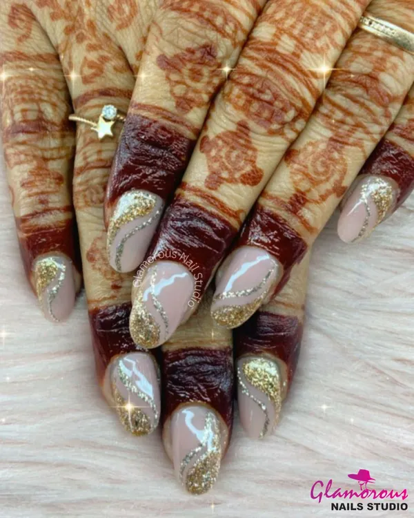 We absolutely love creating the perfect nails for our brides. This design features a dazzling gold glitter that fades into a soft nude base, accented with delicate silver swirls. It’s the perfect complement to intricate mehndi, creating a look of pure festive elegance.
