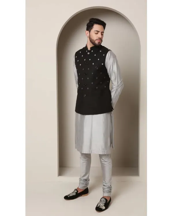 The 'Shoorveer' set is my modern interpretation of a classic. I've paired a black Bandi jacket, detailed with minimal silver embroidery, with a shimmering grey-silver kurta and churidar for a look that is both understated and sophisticated.