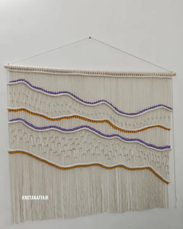 This beautiful 4-foot by 3.5-foot macraweave wall hanging was a recent custom order. I wove in shades of purple and mustard as requested by the client to create this wavy, textured design. If you want a unique piece for your home, I'm just a message away.