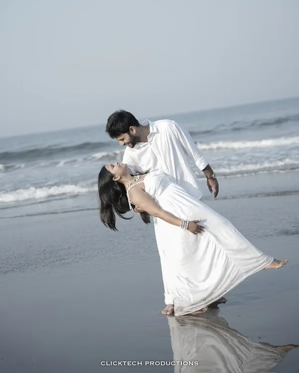 A classic romantic dip pose on a Goan beach, with the waves washing over their feet, creating a timeless and cinematic pre-wedding photo.