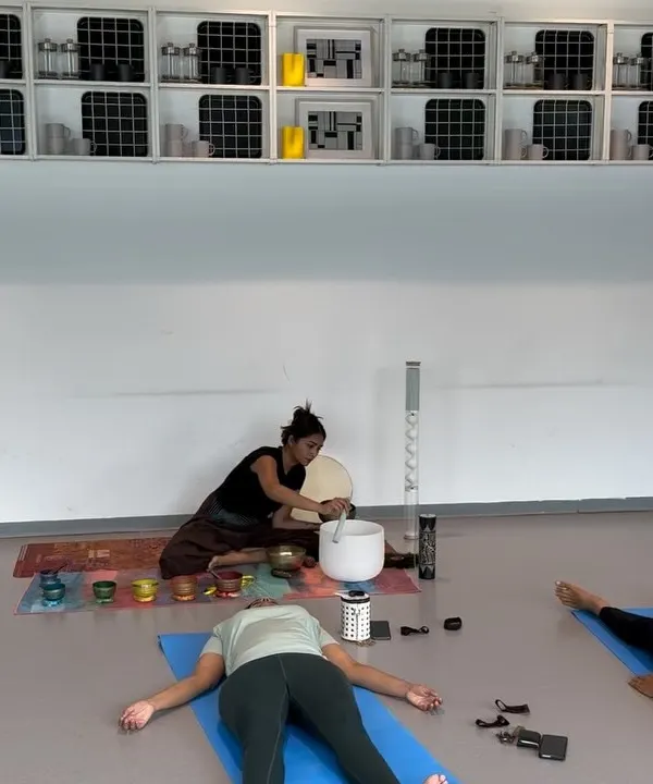 During a personalized session, a client rests in Savasana while I play the crystal singing bowl. The focused attention in a private setting allows for a much deeper and more targeted healing experience.