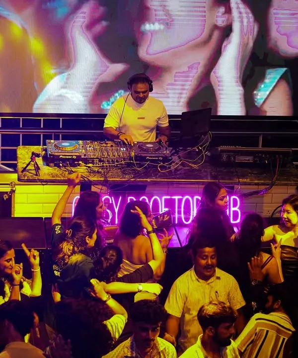 A wide shot from my console at Gypsy Tower Rooftop. You can see how the large LED screen behind me becomes part of the show, with visuals that match the energy of the Bollywood tracks I'm playing for the packed dancefloor.