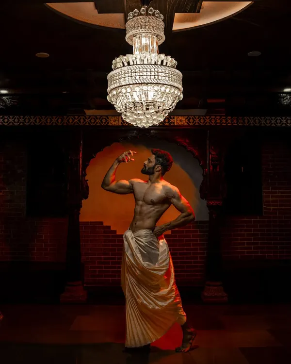A powerful and artistic shot featuring a male model in a perfectly draped dhoti. This showcases a modern, royal look for grooms.