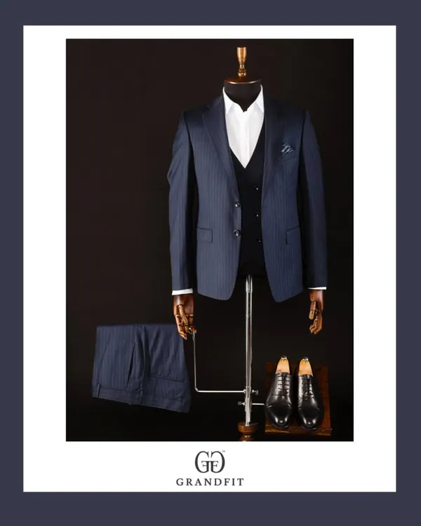 A classic navy pinstripe three-piece suit, the epitome of corporate elegance. The waistcoat adds a formal touch, while the pinstripes convey a sense of tradition and authority.