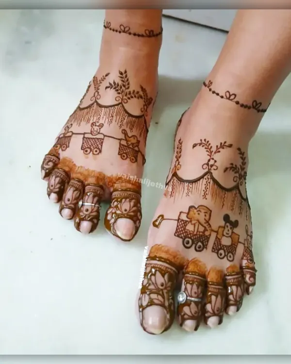 A super cute and playful design for a baby shower. The feet are adorned with a toy train carrying an elephant and a teddy bear, with a delicate vine anklet.
